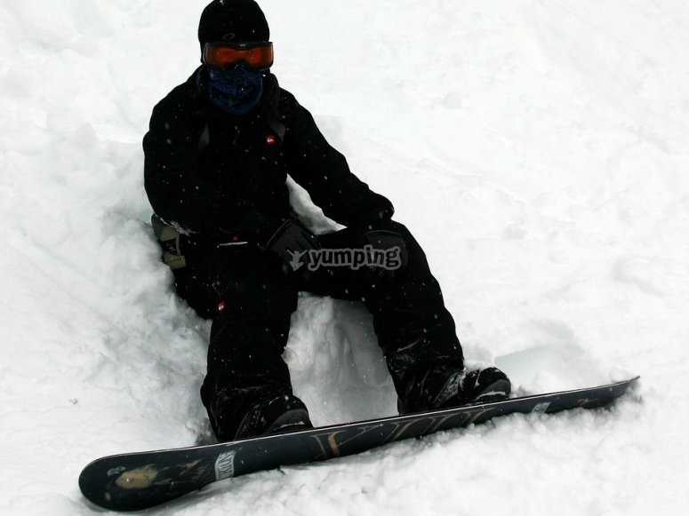 Sentado en la nieve con la tabla de snow Sentado en la nieve con la tabla de snow